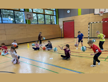 Kinder in der Sporthalle bei Basketball-Übungen