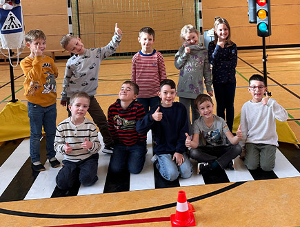 Schüler in der Sporthalle mit Verkehrsschilder